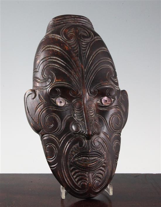 A mother of pearl inset carved hardwood Maori wall mask, 13in.